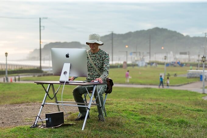 公園でPCを見る男性